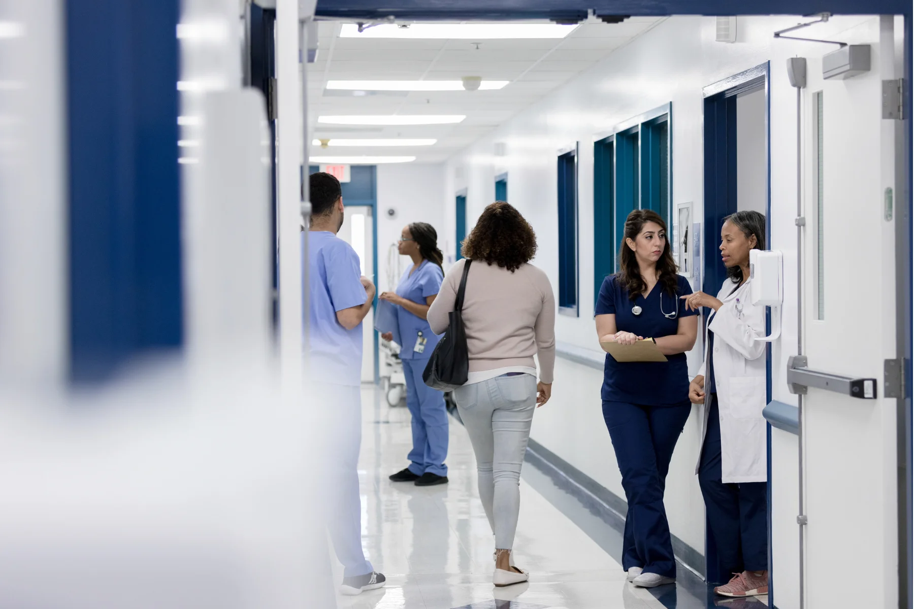 Échanges entre professionnels de santé dans un couloir hospitalier — gouvernance et coordination au quotidien
